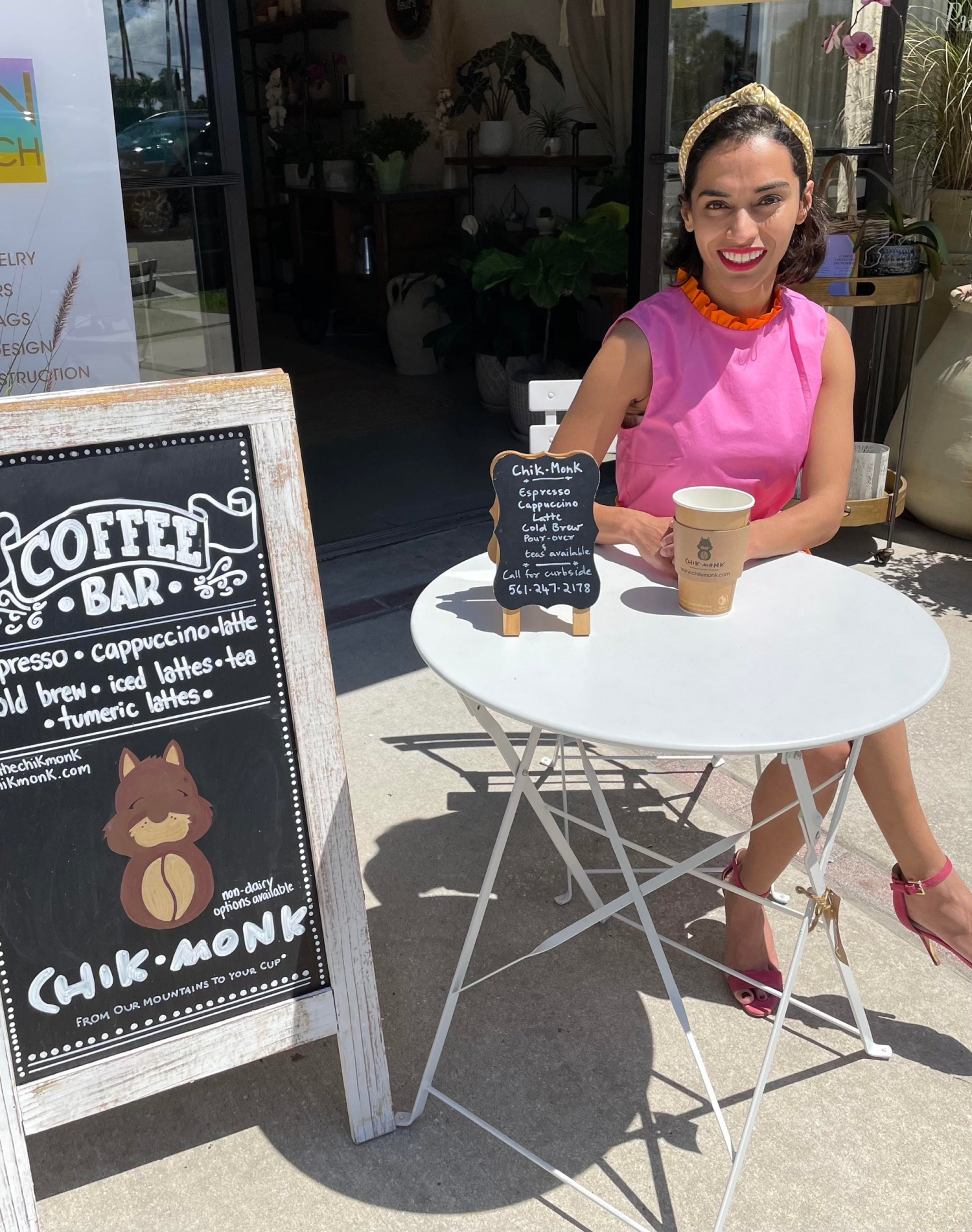 Woman enjoying coffee at outdoor table next to Chikmonk Coffee Bar sign, taking an unexpected nontraditional path with her business