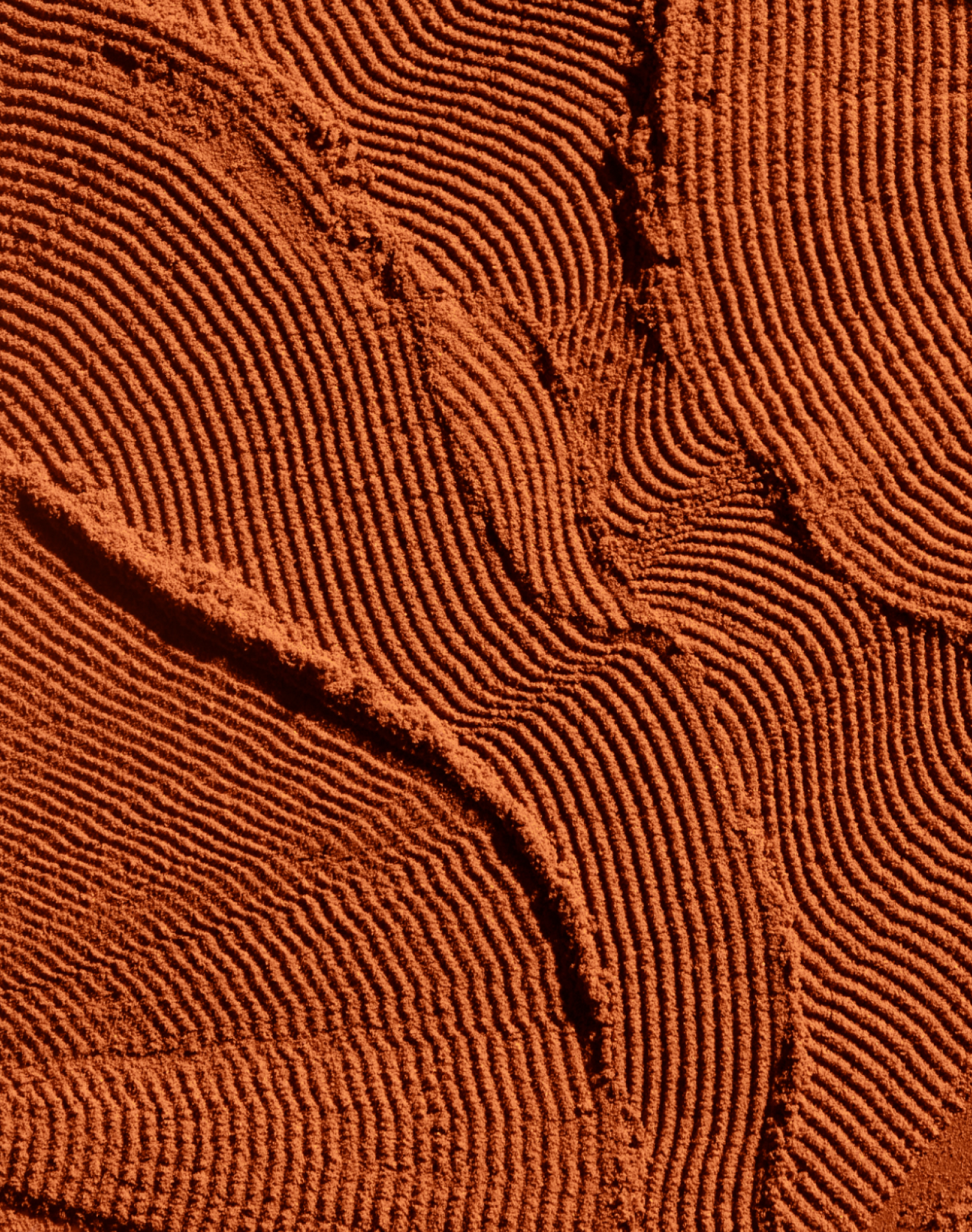 Close-up texture of vibrant orange turmeric powder with fine ridges and patterns
