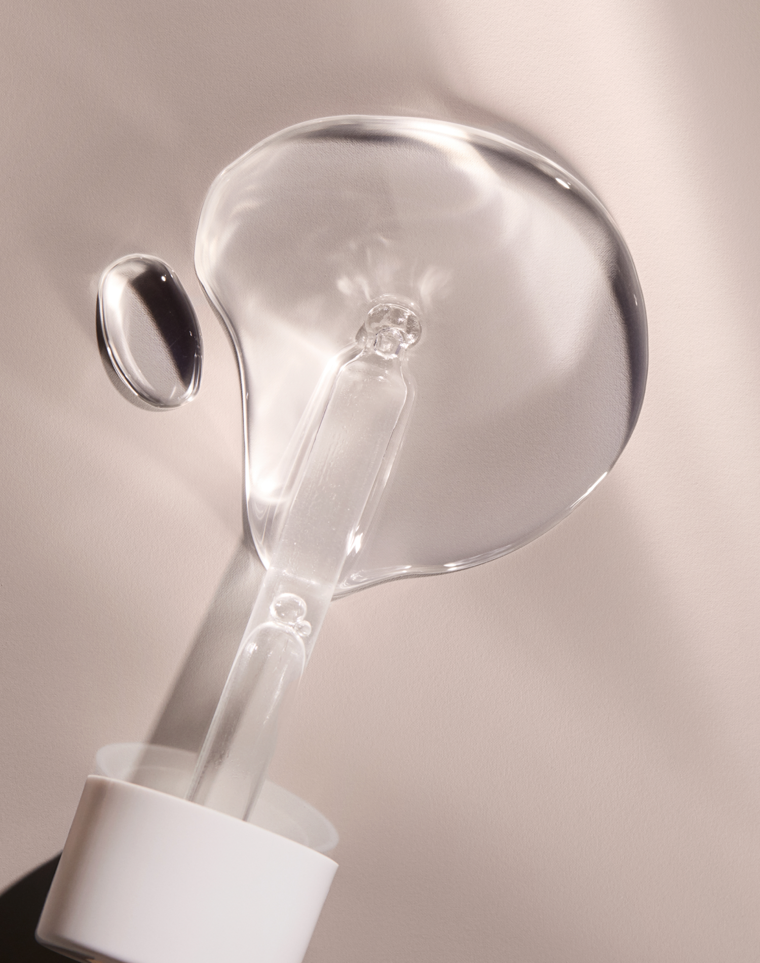 Clear skincare serum droplet on white dropper against beige background for skincare routine benefits