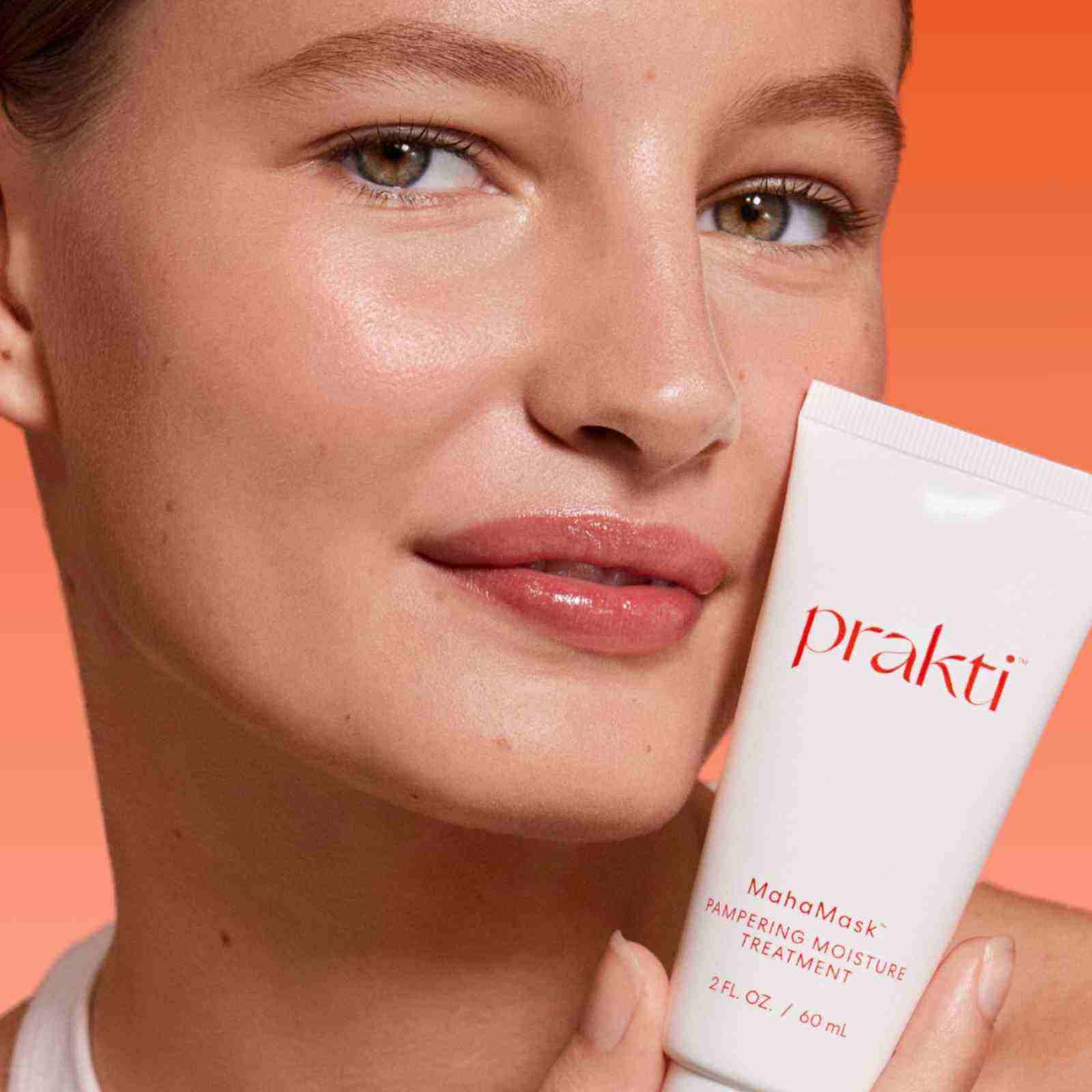 woman holding MahaMask moisturizing mask for glowing skin close-up