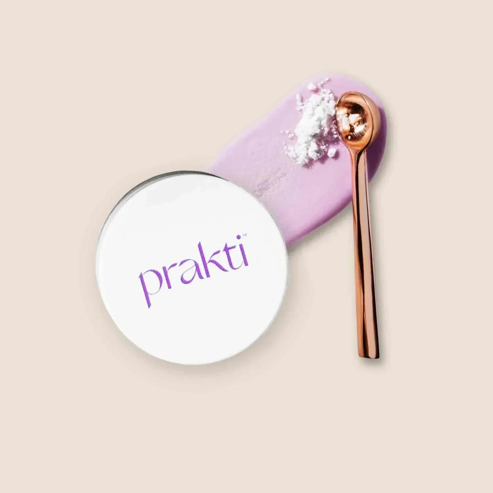prakti PritiPolish exfoliating lip treatment with rose gold spoon and purple smear on beige background